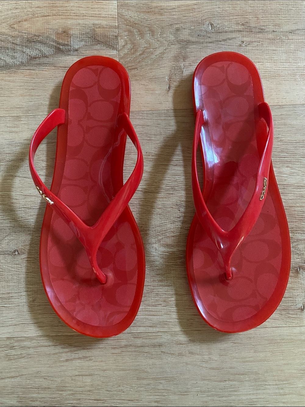 Coach coral-red flip-flops with gold-toned hardware